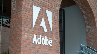 Image of the brick outside of the Adobe Building, with the word Adobe and a white A logo on the wall. 