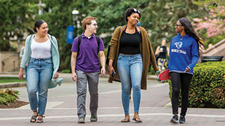 A group of undergraduate students walking on campus.