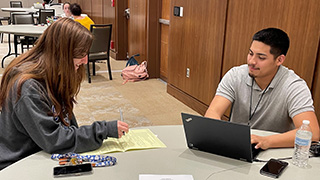 Photo of customer taking advantage of the complimentary tax prep services offered on campus in March by VITA program volunteers.