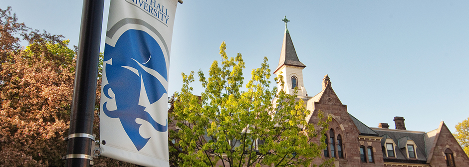 Seton Hall pole banner with President's Hall in the background.