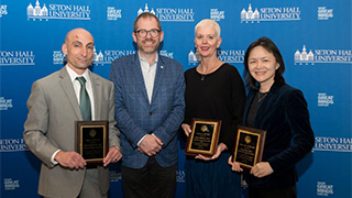Award-winning professors from the College of Human Development, Culture, and Media, from left, Angelo Gingerelli, Renee Robinson, and Rong Chen pose with Dean Bryan Crable. Photo credit: Joy Yagid