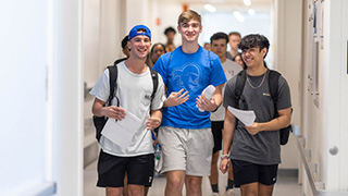 Interprofessional Health Sciences students walk through a hallway.