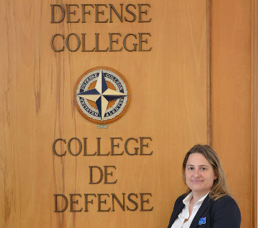 Dr. Sara Bjerg Moller in front of the NATO Defense College sign.