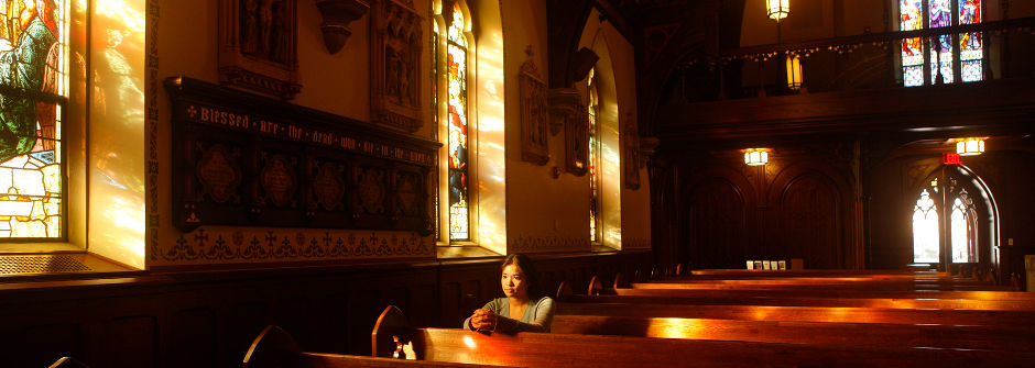 Student in a pew in the chapel. 
