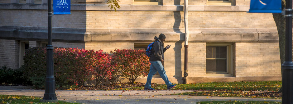 A student walking on the Seton Hall campus.
