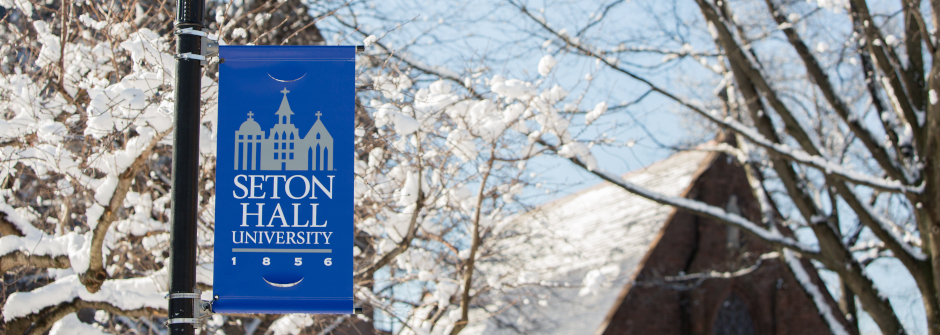 Seton Hall University banner covered in snow in winter.
